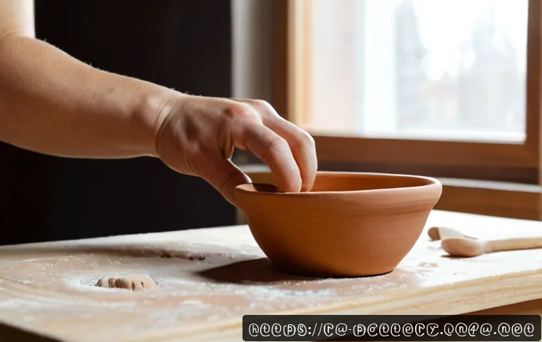 Home 17 핸드빌딩 기법 - Photorealistic close-up of an adult craftsperson using the pinch-pot hand-building technique to shap...